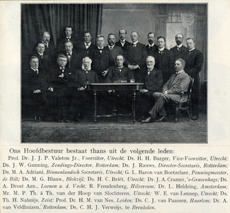105279 Groepsportret van de leden van het hoofdbestuur van de Utrechtse Zendingsvereniging, zittend en staand om een tafel.